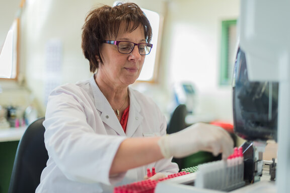 Labor Mitarbeiterin entnimmt Proben aus Reagenzgläsern 